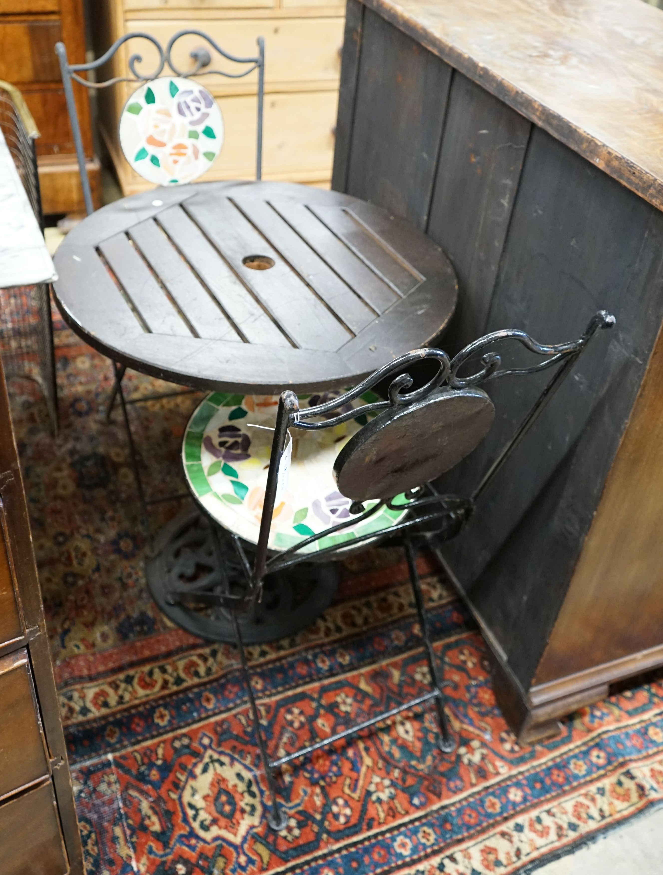 A circular cast iron based garden table, diameter 60cm together with two wrought iron mosaic folding chairs